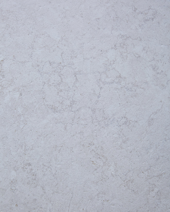Close-up of the Brit Stone Minster Porcelain surface, showing its soft pale limestone tone and fine mottled veining