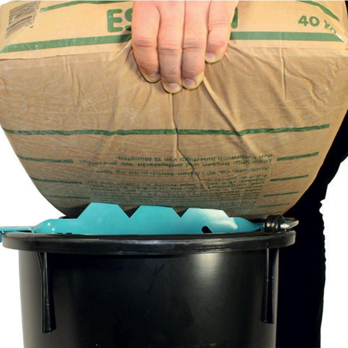 Sharky Bag Ripper with teal prongs positioned on bucket rim for bag emptying