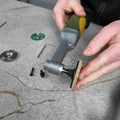 Person using a Distar polishing support tool on a concrete surface with small objects around