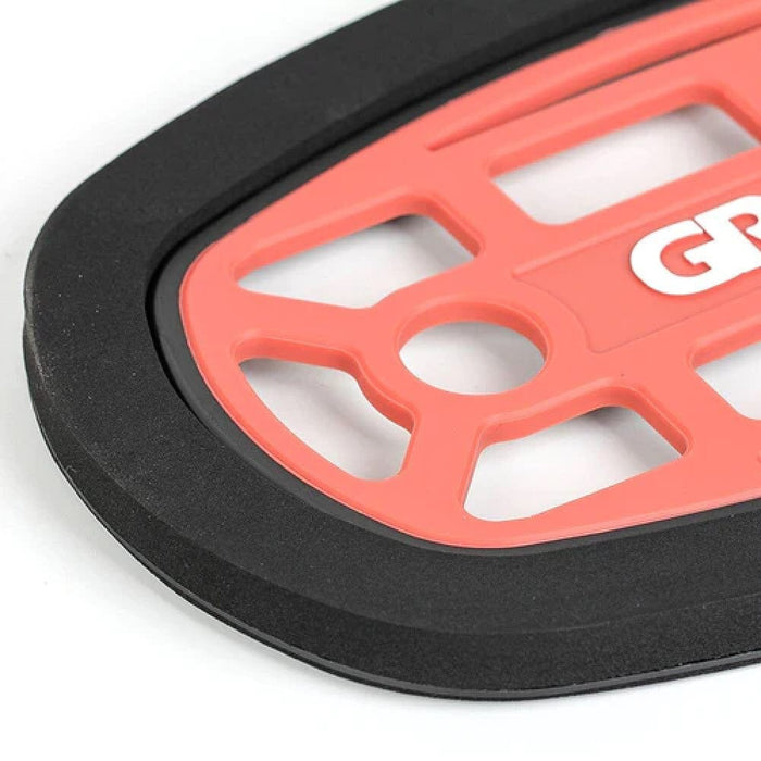 Close-up of red grip plate with cut-out pattern and thick black rim