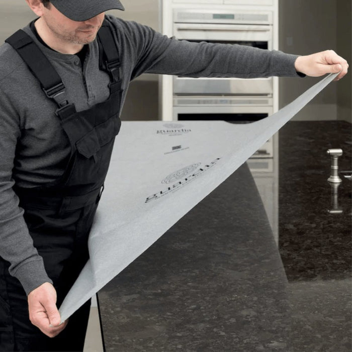 Worker applying White Pro surface protection sheet to a floor area for protection