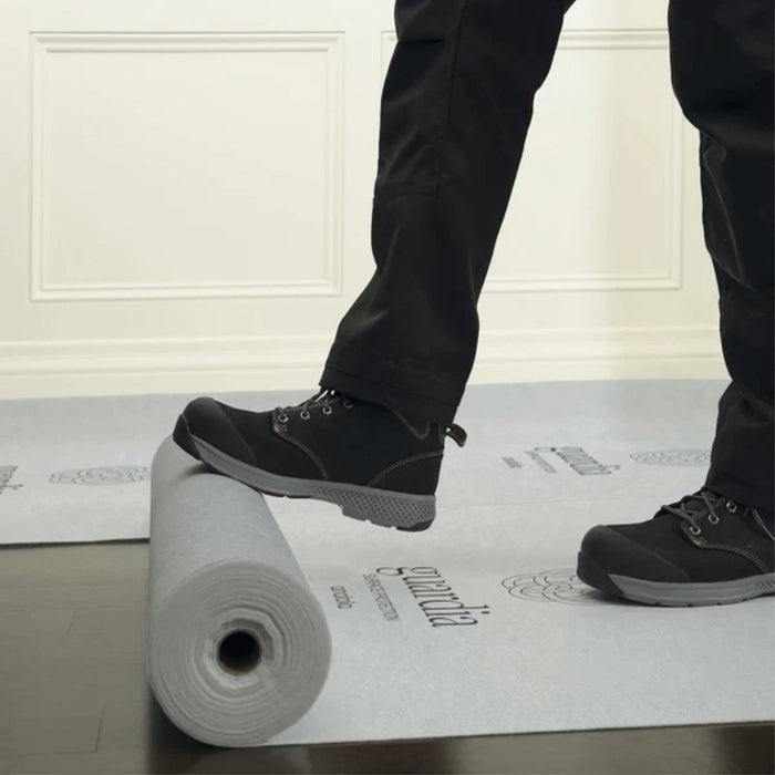 White Pro surface protection on floor with roll nearby and worker boots standing on it