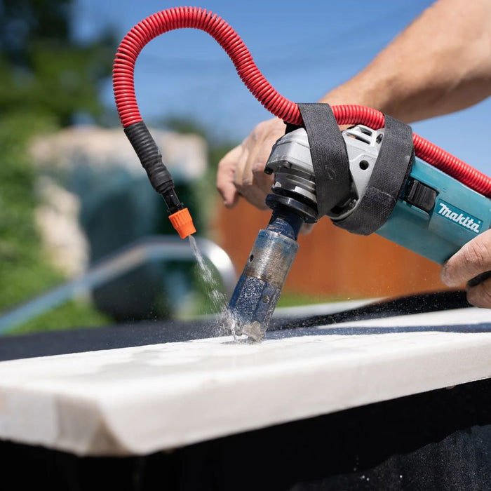 Universal water attachment with red hose delivering water to a surface while cutting
