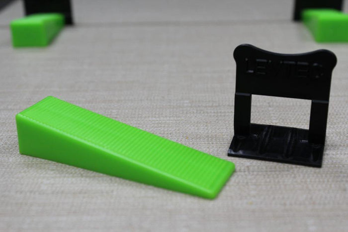 Green tile leveling wedges with black leveling base stand