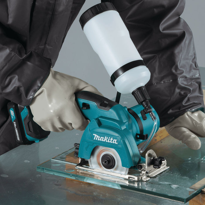 Cordless tile saw with dust protection and gloves when cutting through tiles