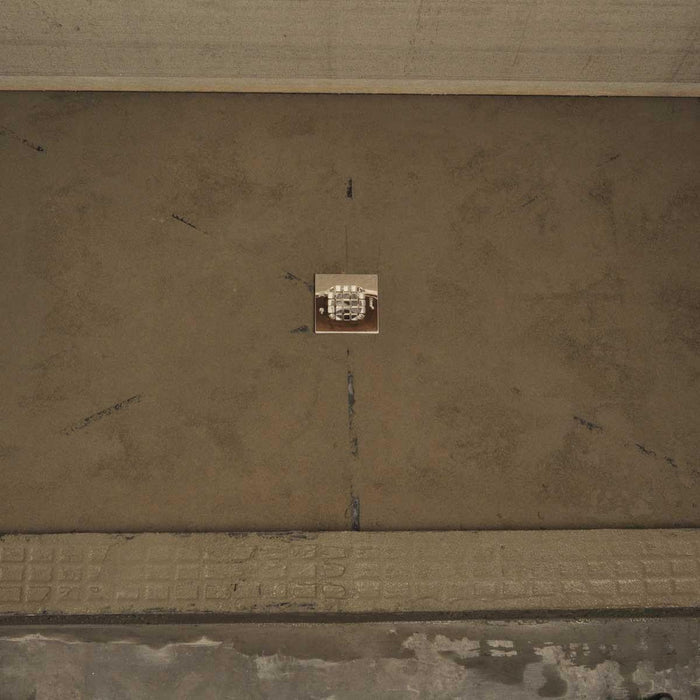 Quick Pitch shower floor drainage base plate centered on concrete subfloor