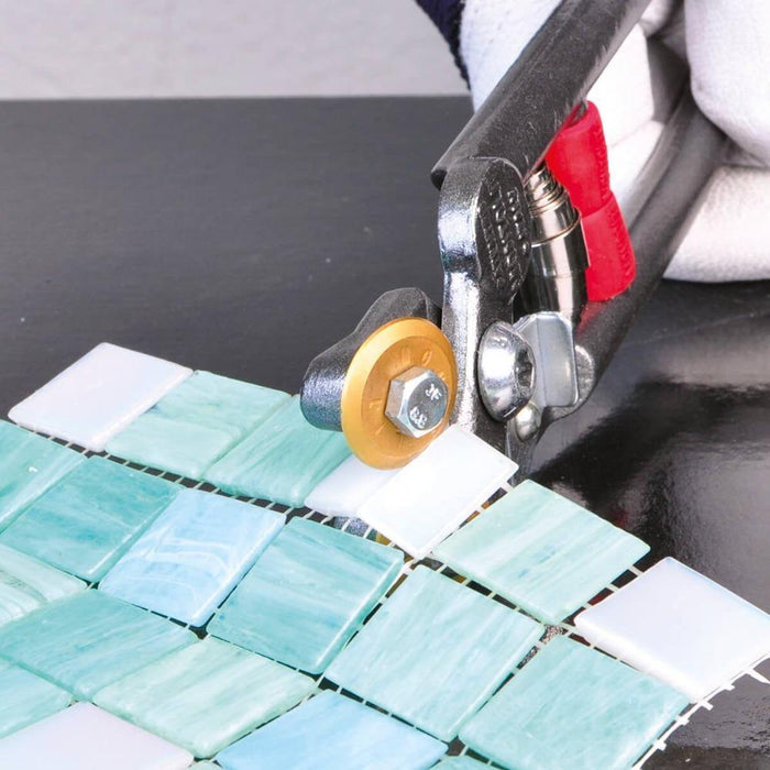 Mosaic nippers trimming turquoise and white ceramic/glass tiles
