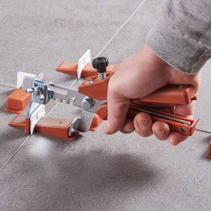 HD tile leveling system in use: hand tightens orange clamp with 1/16" clips