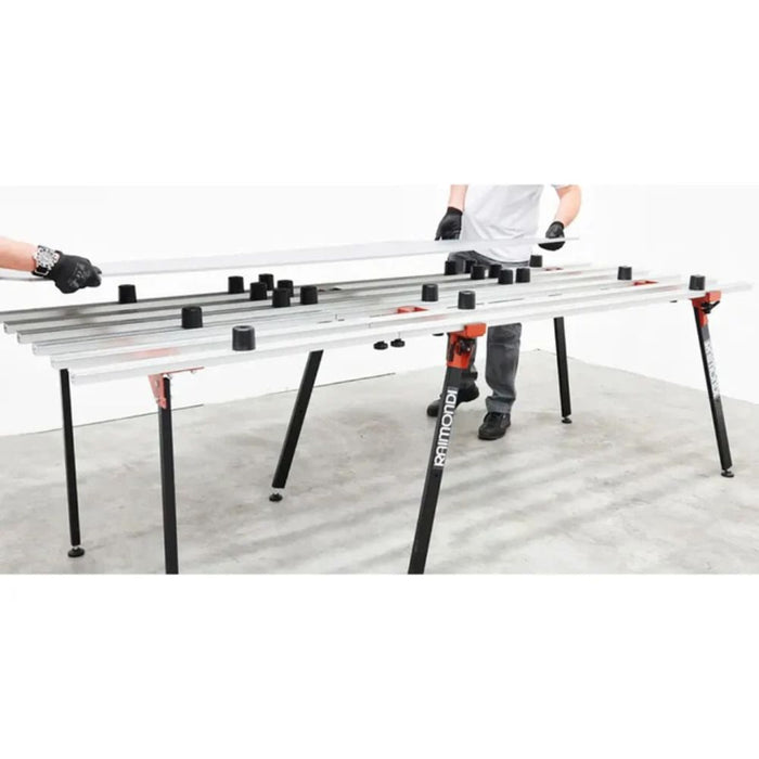 Tile leveling setup with black cylinder supports on a metal leveling bar