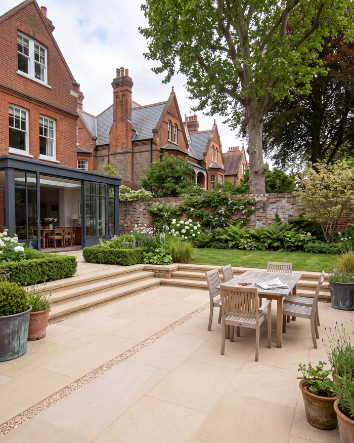Wensley York Sandstone Honed paving and matching steps leading down from a lawn to a sunken dining terrace outside a red brick Victorian house